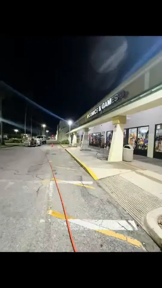 Night washing of storefronts, awnings and signs at a shopping plaza.