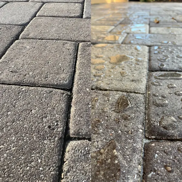 Close up of gray pavers, dull rough stones on the left and wetter lighter stones on the right
