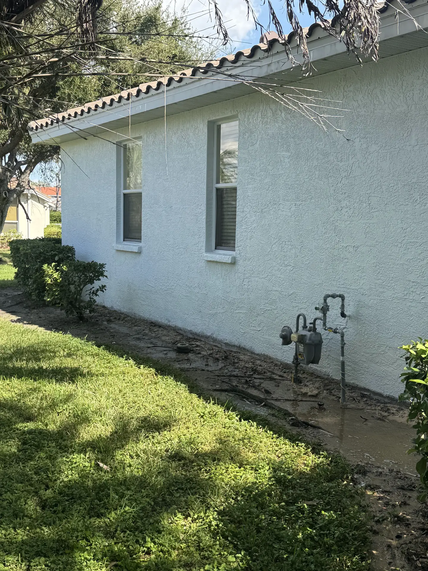 The same stucco wall after washing, white and even with the orange staining gone