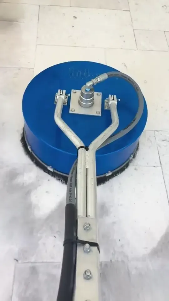 A rotary surface cleaner works over dull pale stone tile, from the dirty start to a clean pool deck.