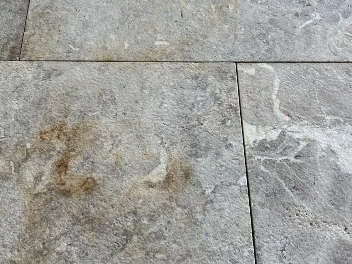Gray natural stone tile with an orange rust stain