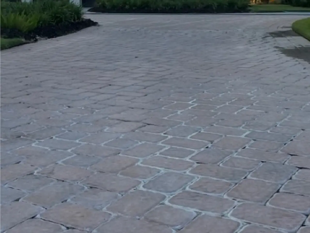 A driveway of gray, faded pavers