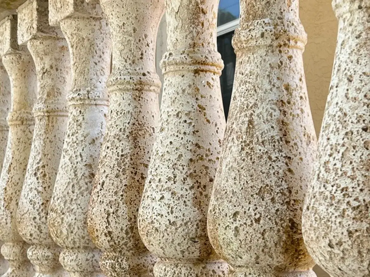 Stone balusters streaked green and brown with algae
